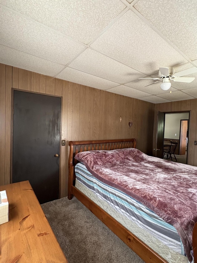 22347 5 Mile Rd, Morley, MI 49336 - bedroom featuring a drop ceiling, carpet flooring, wood walls, and ceiling fan