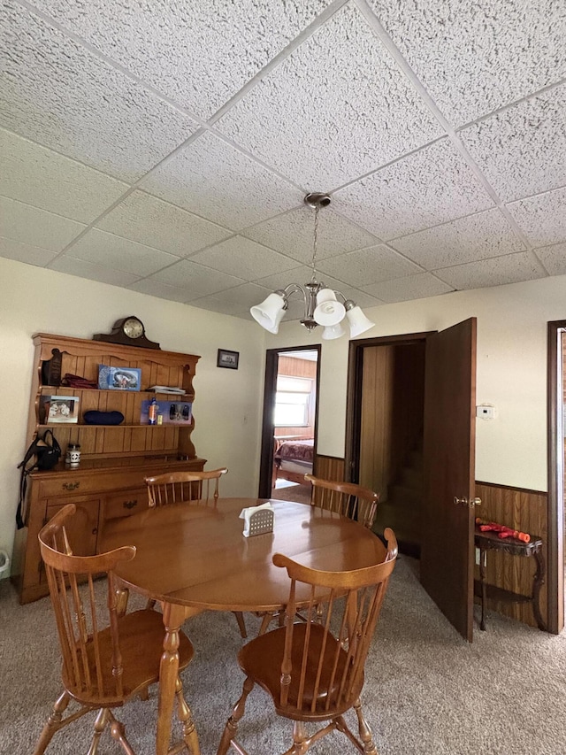 22347 5 Mile Rd, Morley, MI 49336 - carpeted dining room featuring a paneled ceiling, a wainscoted wall, stairs, and wooden walls