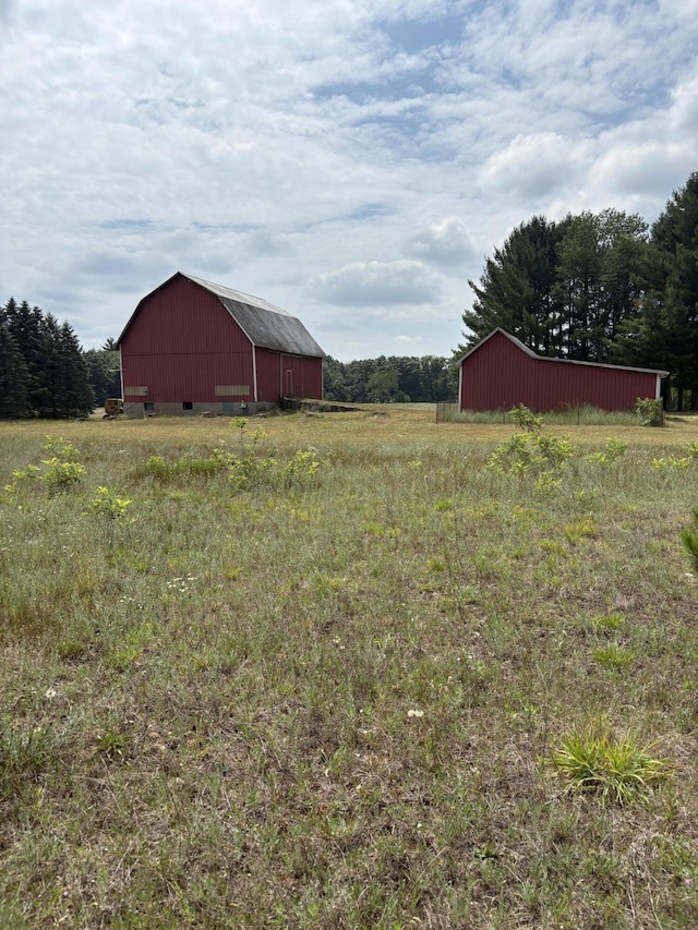 22347 5 Mile Rd, Morley, MI 49336 - view of yard with a barn, an outbuilding, a garage, and a rural view
