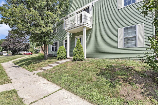 1415 Wingate Blvd, Ypsilanti, MI 48198 - view of home's exterior with a balcony and a lawn