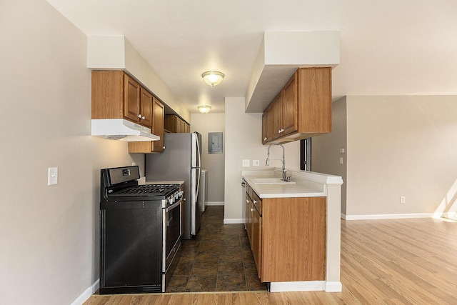 1415 Wingate Blvd, Ypsilanti, MI 48198 - kitchen featuring appliances with stainless steel finishes, under cabinet range hood, light countertops, brown cabinetry, and electric panel