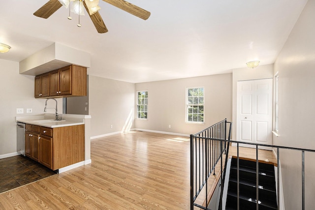1415 Wingate Blvd, Ypsilanti, MI 48198 - kitchen featuring light wood-type flooring, light countertops, brown cabinets, stainless steel dishwasher, and a ceiling fan