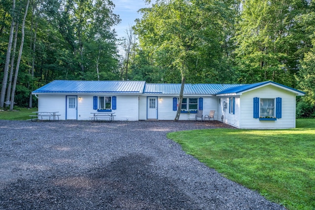 1051 Vallado Dr, Weidman, MI 48893 - ranch-style house with a front yard, a metal roof, and driveway