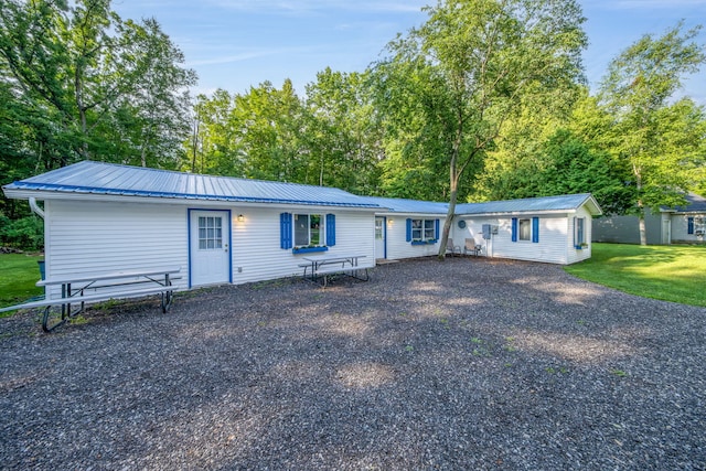 1051 Vallado Dr, Weidman, MI 48893 - view of front of house featuring a metal roof, a front yard, driveway, and view of wooded area