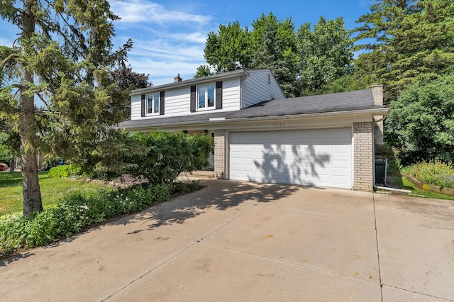 2145 Steeplechase Dr, Ann Arbor, MI 48103 - view of front facade featuring a chimney, brick siding, concrete driveway, and an attached garage