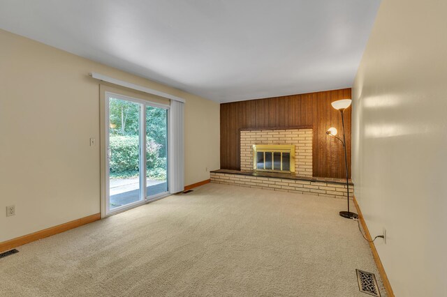 2145 Steeplechase Dr, Ann Arbor, MI 48103 - unfurnished living room featuring carpet, wooden walls, and a fireplace