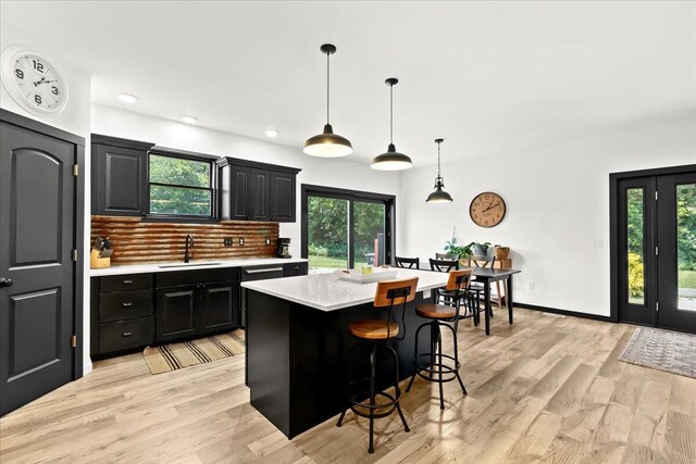 7499 Mathews Rd, Spring Arbor, MI 49283 - kitchen featuring light countertops, dark cabinets, hanging light fixtures, light wood-style flooring, and recessed lighting