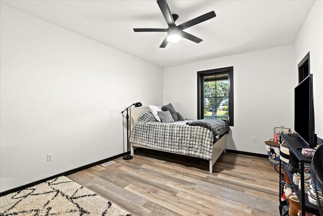 7499 Mathews Rd, Spring Arbor, MI 49283 - bedroom with light wood finished floors and ceiling fan