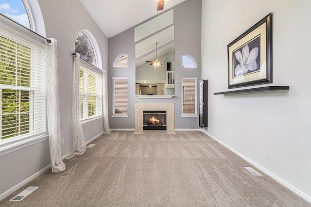 7400 Willow Creek Dr, Ypsilanti, MI 48197 - unfurnished living room featuring a ceiling fan, carpet flooring, high vaulted ceiling, and a tiled fireplace