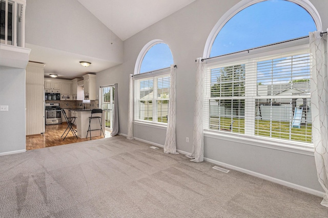 7400 Willow Creek Dr, Ypsilanti, MI 48197 - unfurnished living room with light colored carpet and vaulted ceiling