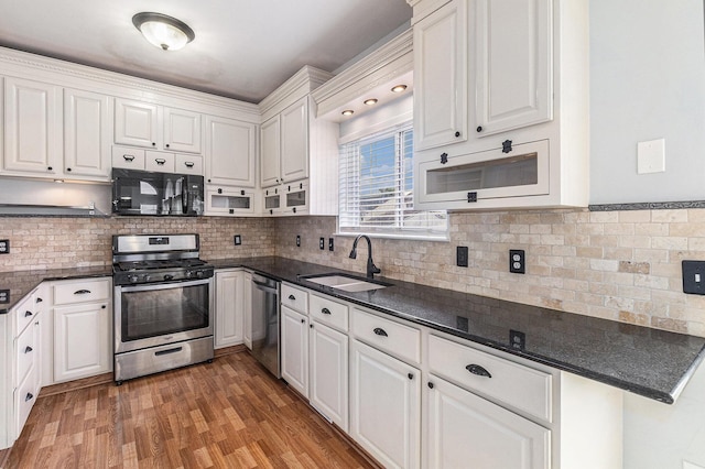 7400 Willow Creek Dr, Ypsilanti, MI 48197 - kitchen with stainless steel appliances, white cabinetry, light wood-style floors, and decorative backsplash