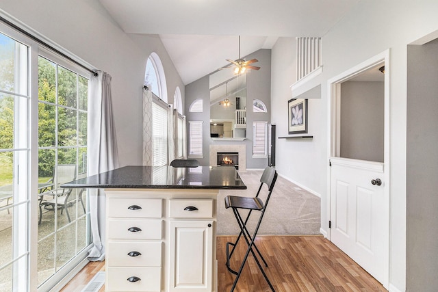 7400 Willow Creek Dr, Ypsilanti, MI 48197 - kitchen with lofted ceiling, light wood-style flooring, a ceiling fan, white cabinets, and open floor plan