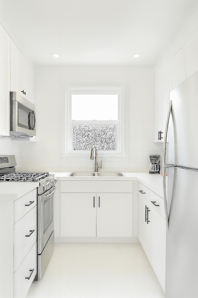 111 Butternut St, Three Oaks, MI 49128 - kitchen with stainless steel appliances, white cabinetry, backsplash, light countertops, and recessed lighting