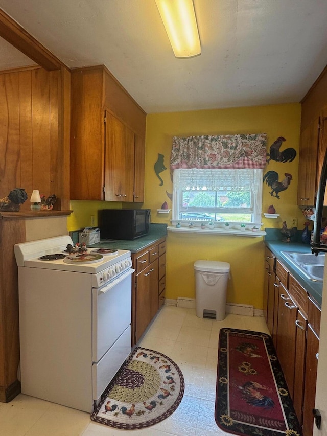 111 Butternut St, Three Oaks, MI 49128 - kitchen with white electric stove, black microwave, and brown cabinets