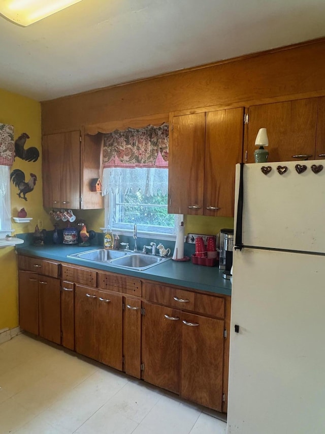 111 Butternut St, Three Oaks, MI 49128 - kitchen with freestanding refrigerator, brown cabinetry, and dark countertops