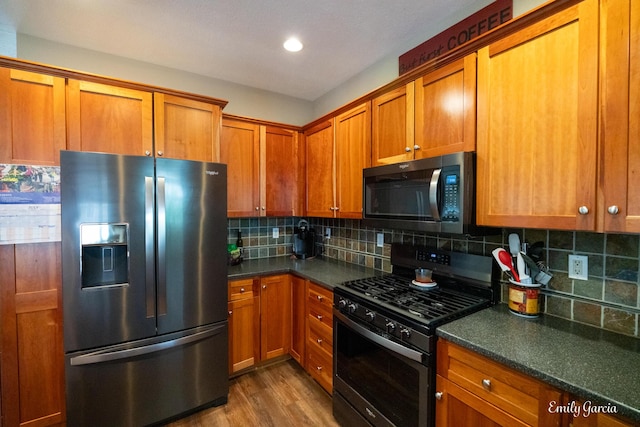 622 Cedar Square St, Holland, MI 49423 - kitchen with stainless steel fridge with ice dispenser, range with gas stovetop, dark countertops, brown cabinetry, and decorative backsplash