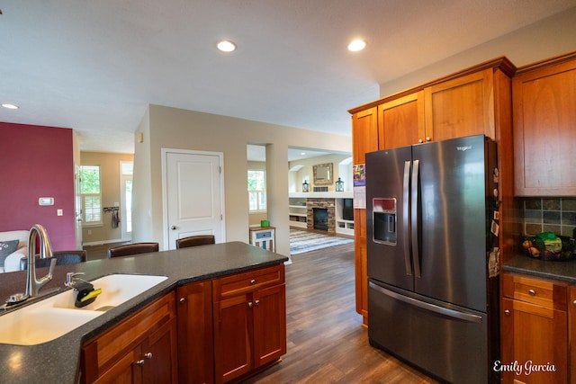 622 Cedar Square St, Holland, MI 49423 - kitchen with stainless steel refrigerator with ice dispenser, dark wood-style floors, recessed lighting, backsplash, and a fireplace