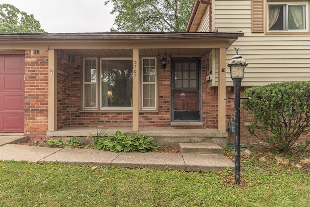 2707 Brandywine Dr, Ann Arbor, MI 48104 - view of exterior entry with a porch, brick siding, and an attached garage