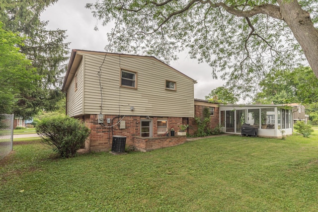 2707 Brandywine Dr, Ann Arbor, MI 48104 - back of house with a sunroom, brick siding, and a yard