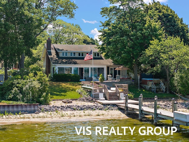 537 Buena Vista Dr, Spring Lake, MI 49456 - view of front of home featuring a deck with water view, a fire pit, a chimney, a dock, and a front yard