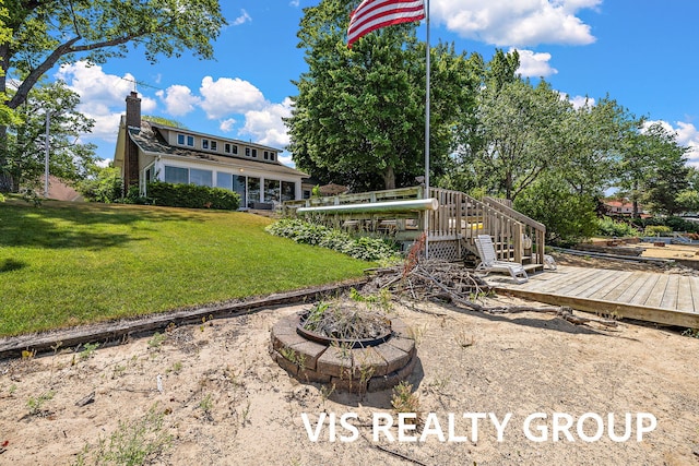 537 Buena Vista Dr, Spring Lake, MI 49456 - rear view of property with a wooden deck, a lawn, a fire pit, and a chimney
