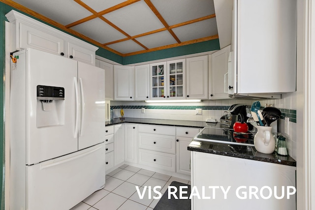 537 Buena Vista Dr, Spring Lake, MI 49456 - kitchen featuring white refrigerator with ice dispenser, dark countertops, white cabinets, glass insert cabinets, and light tile patterned floors