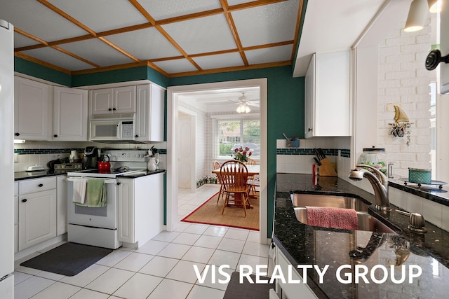 537 Buena Vista Dr, Spring Lake, MI 49456 - kitchen with white appliances, backsplash, light tile patterned flooring, white cabinetry, and a ceiling fan