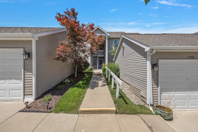 1734 Weatherstone Dr, Ann Arbor, MI 48108 - property entrance with roof with shingles and a garage