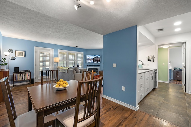 1734 Weatherstone Dr, Ann Arbor, MI 48108 - dining room with a lit fireplace, dark wood-type flooring, and a textured ceiling