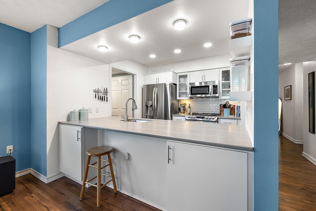 1734 Weatherstone Dr, Ann Arbor, MI 48108 - kitchen with stainless steel appliances, a peninsula, dark wood-style flooring, and recessed lighting