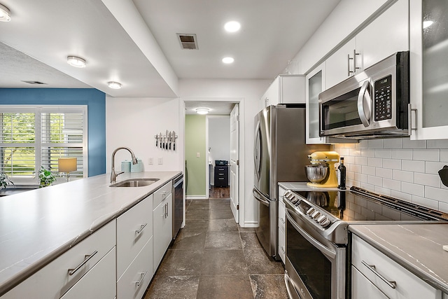 1734 Weatherstone Dr, Ann Arbor, MI 48108 - kitchen featuring appliances with stainless steel finishes, backsplash, white cabinets, recessed lighting, and glass insert cabinets
