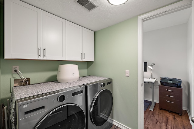 1734 Weatherstone Dr, Ann Arbor, MI 48108 - washroom featuring separate washer and dryer, cabinet space, dark wood-style flooring, and a textured ceiling