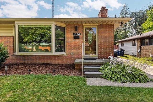 1534 Barrington Pl, Ann Arbor, MI 48103 - property entrance featuring brick siding, a chimney, and a lawn