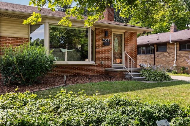 1534 Barrington Pl, Ann Arbor, MI 48103 - view of front of home with a chimney, brick siding, and a front yard