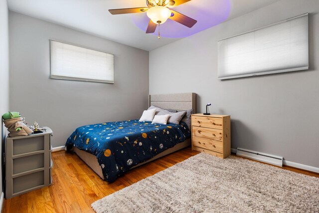 1534 Barrington Pl, Ann Arbor, MI 48103 - bedroom featuring a baseboard radiator, wood finished floors, and ceiling fan
