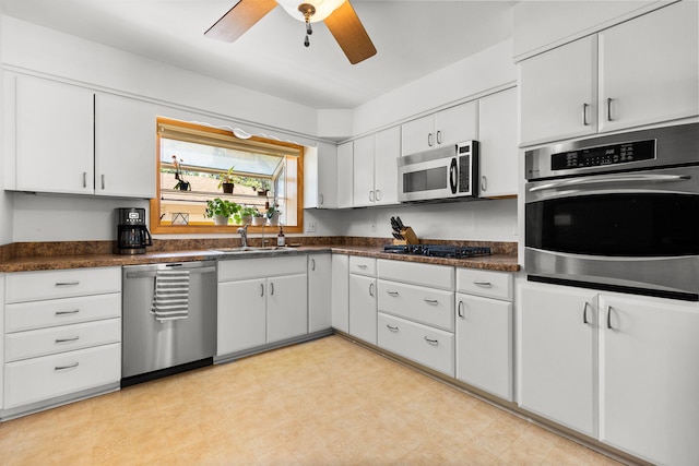 1534 Barrington Pl, Ann Arbor, MI 48103 - kitchen featuring stainless steel appliances, dark countertops, white cabinetry, and ceiling fan