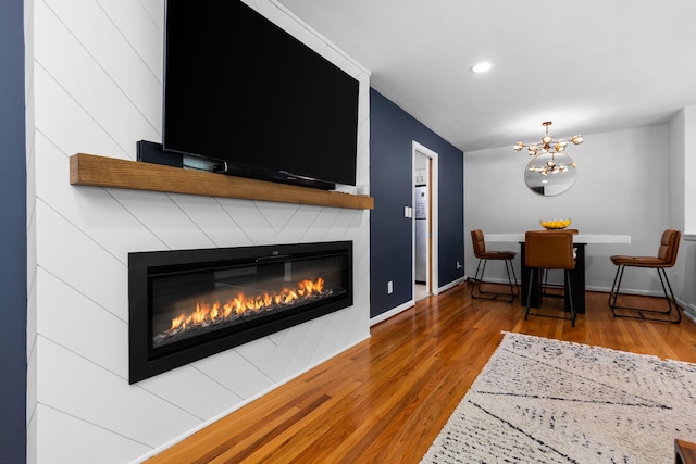 1534 Barrington Pl, Ann Arbor, MI 48103 - living room with a large fireplace, wood finished floors, a chandelier, and recessed lighting