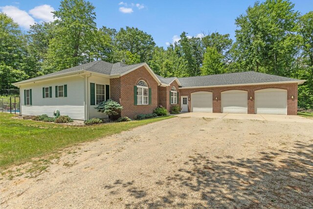 23103 13 Mile Rd, Big Rapids, MI 49307 - ranch-style home featuring dirt driveway, an attached garage, and brick siding