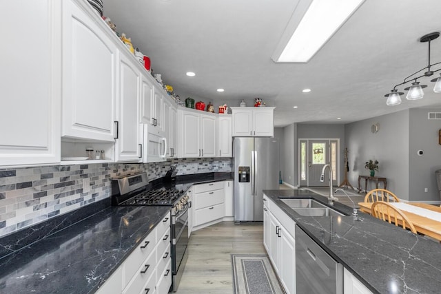 23103 13 Mile Rd, Big Rapids, MI 49307 - kitchen featuring stainless steel appliances, white cabinets, decorative backsplash, light wood-style floors, and recessed lighting