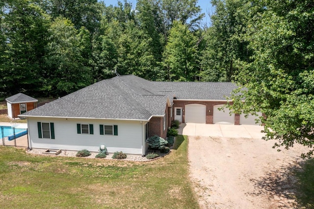 23103 13 Mile Rd, Big Rapids, MI 49307 - ranch-style house featuring concrete driveway, a shingled roof, a front yard, a garage, and a storage shed