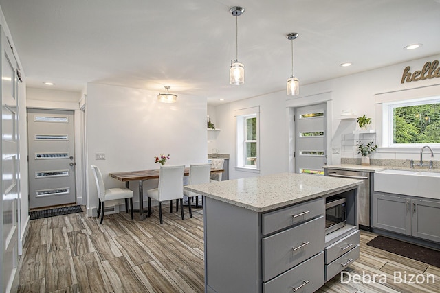 17929 S River Rd, Three Rivers, MI 49093 - kitchen featuring gray cabinets, wood finish floors, a kitchen island, light stone counters, and recessed lighting