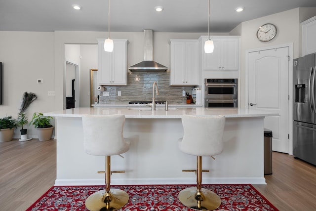 4814 Cranston Rd Unit 86, Canton, MI 48188 - kitchen featuring wall chimney range hood, appliances with stainless steel finishes, decorative backsplash, light wood finished floors, and recessed lighting