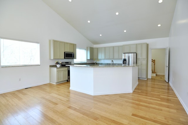 2019 Chalmers Dr, Ann Arbor, MI 48104 - kitchen with appliances with stainless steel finishes, high vaulted ceiling, a center island with sink, light wood-style floors, and recessed lighting
