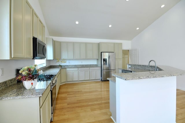 2019 Chalmers Dr, Ann Arbor, MI 48104 - kitchen with stainless steel appliances, light wood-style floors, recessed lighting, light stone counters, and a large island with sink