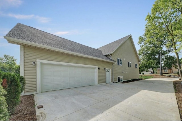 2019 Chalmers Dr, Ann Arbor, MI 48104 - view of side of home featuring concrete driveway, a shingled roof, and an attached garage