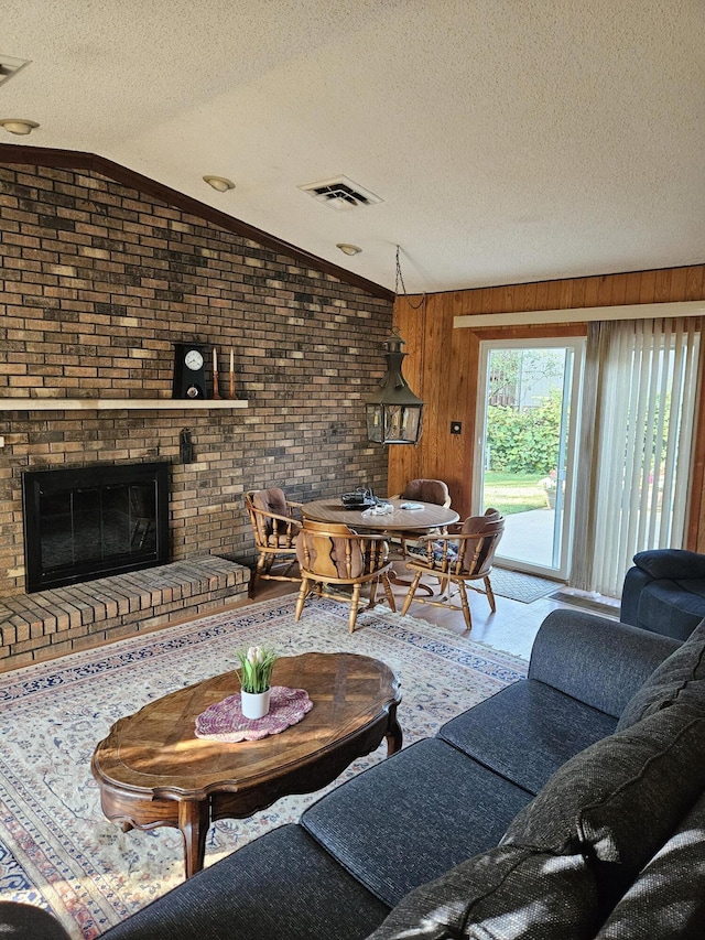 4810 Grandview Dr, Ypsilanti, MI 48197 - living room with a textured ceiling, vaulted ceiling, a fireplace, and wood finished floors
