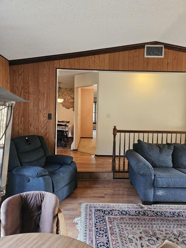 4810 Grandview Dr, Ypsilanti, MI 48197 - living area with wooden walls, wood finished floors, ornamental molding, and a textured ceiling