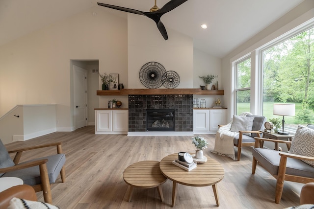 1717 Toscana St, Kalamazoo, MI 49009 - living area with high vaulted ceiling, healthy amount of natural light, a tile fireplace, ceiling fan, and light wood-style floors