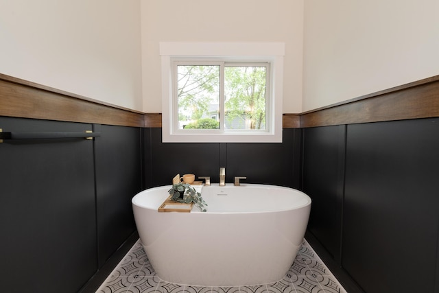 1717 Toscana St, Kalamazoo, MI 49009 - bathroom with a soaking tub, tile patterned flooring, wainscoting, and a decorative wall