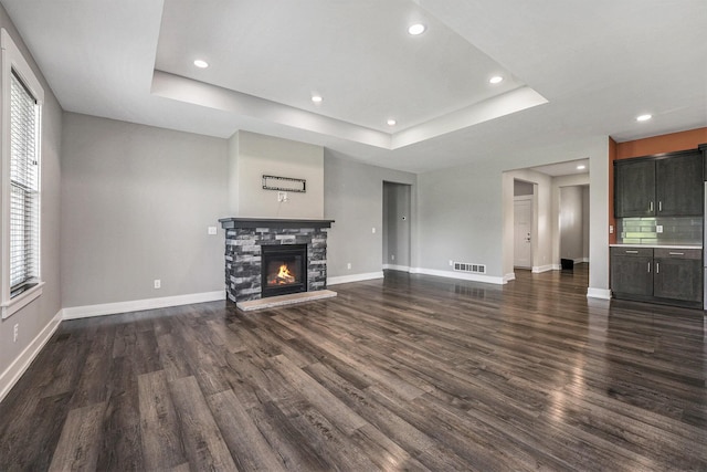 8275 Woodhaven Dr SW, Byron Center, MI 49315 - unfurnished living room with dark wood-style flooring, a tray ceiling, plenty of natural light, and recessed lighting
